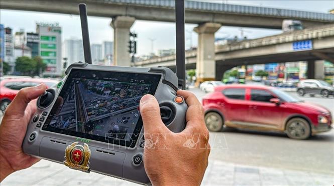 Cán bộ kỹ thuật điều khiển UAV giám sát tình hình giao thông tại khu vực đường Vành đai 3 - Nguyễn Xiển - Nguyễn Trãi. (Ảnh: Trung Nguyên/TTXVN)